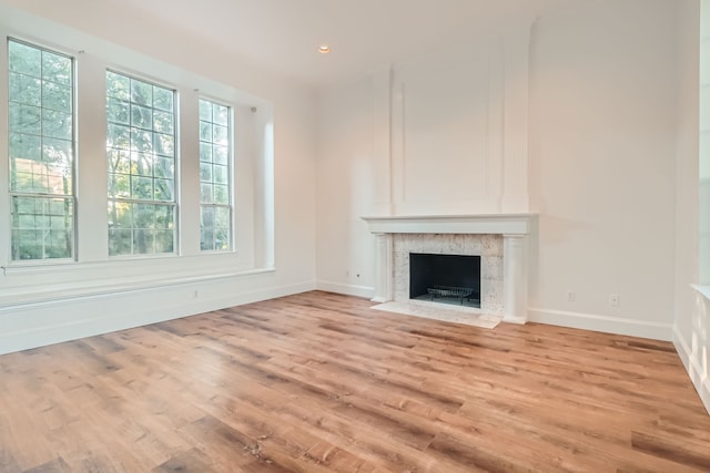 unfurnished living room with light hardwood / wood-style floors and a high end fireplace