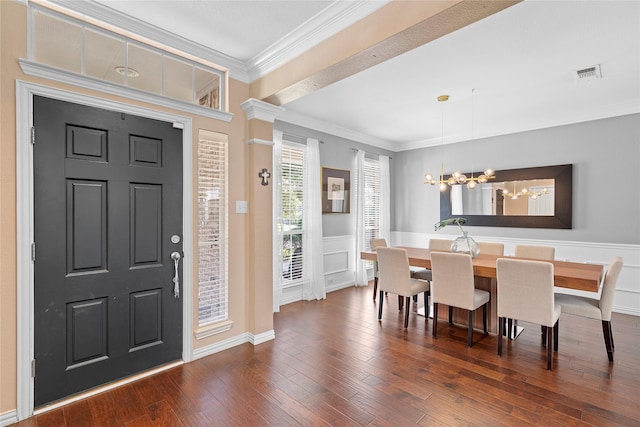 entrance foyer featuring ornamental molding, dark hardwood / wood-style floors, and a chandelier