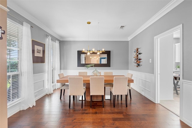 dining room featuring an inviting chandelier, ornamental molding, and dark hardwood / wood-style flooring