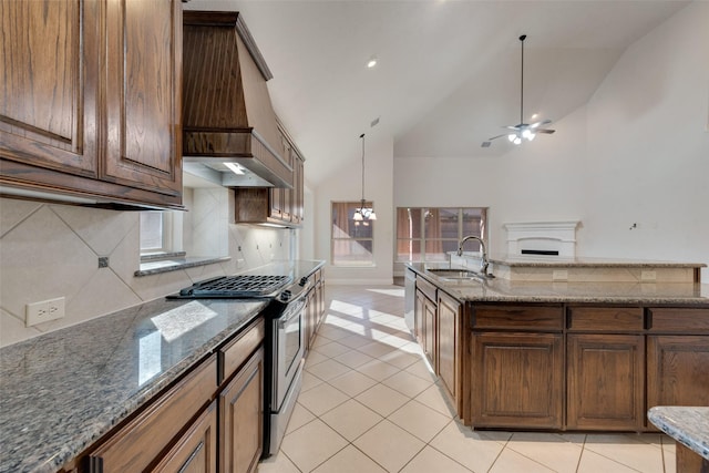 kitchen featuring decorative backsplash, stainless steel range with gas cooktop, sink, and lofted ceiling