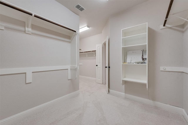 walk in closet featuring light colored carpet