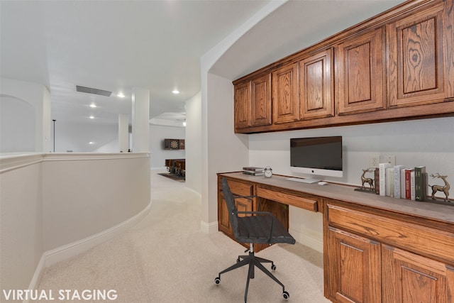 office space with built in desk and light colored carpet