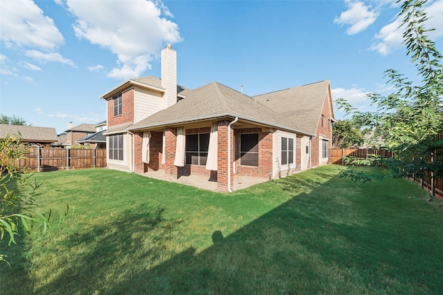 back of property with a yard and a patio