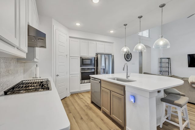 kitchen with a kitchen island with sink, sink, stainless steel appliances, and white cabinets