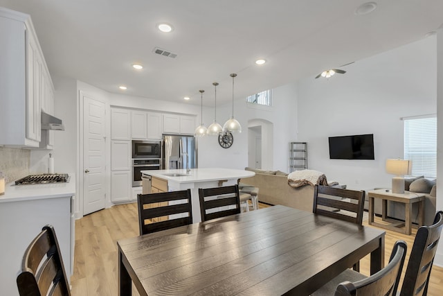 dining space with light wood-type flooring and sink