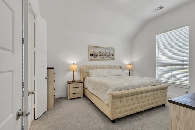 bedroom with multiple windows, vaulted ceiling, and light colored carpet