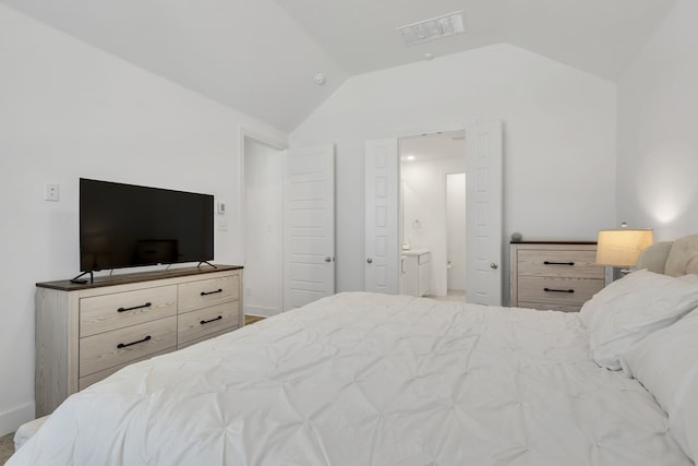 bedroom with ensuite bath and vaulted ceiling