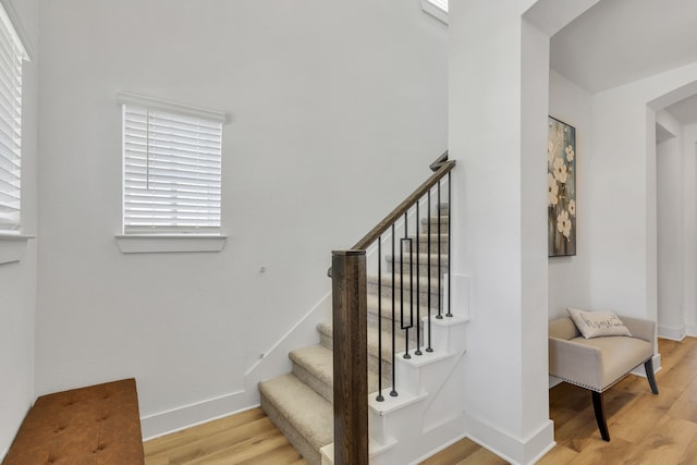 stairs with hardwood / wood-style flooring and a healthy amount of sunlight