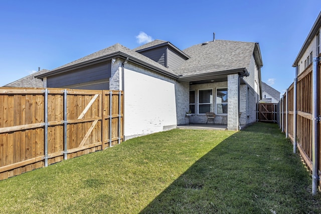 rear view of house with a lawn and a patio area