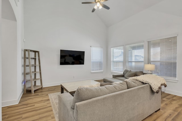 living room featuring ceiling fan, light hardwood / wood-style floors, and high vaulted ceiling