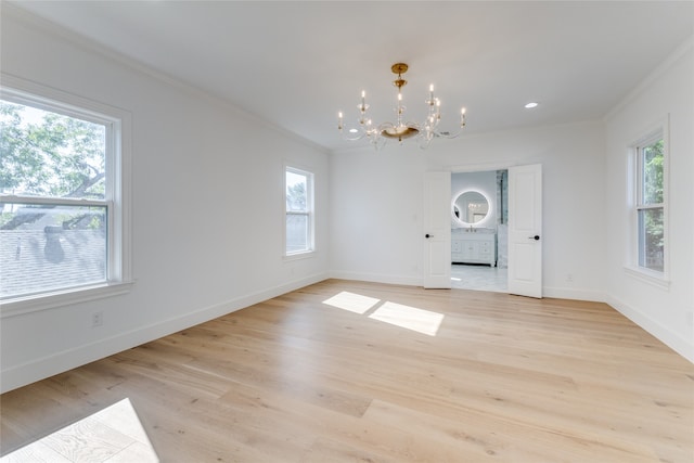 unfurnished dining area with a notable chandelier, ornamental molding, light hardwood / wood-style flooring, and a healthy amount of sunlight