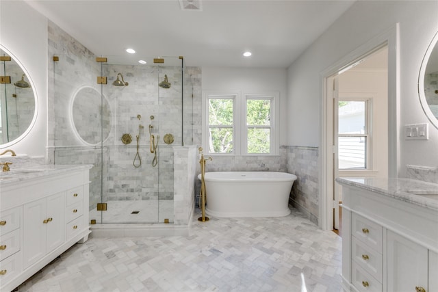 bathroom with tile walls, vanity, and shower with separate bathtub