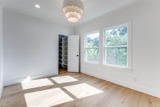 unfurnished room featuring ornamental molding and light wood-type flooring