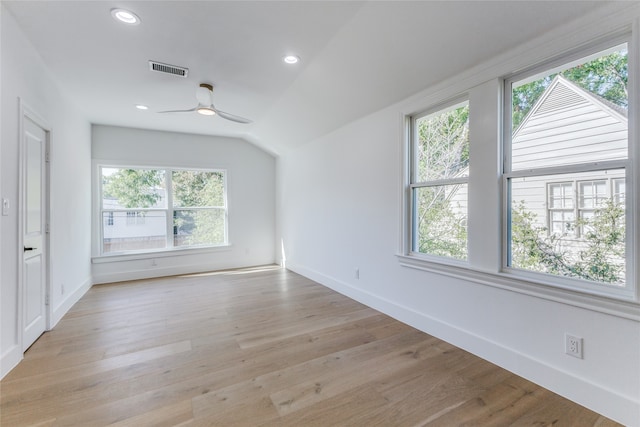 unfurnished room with light hardwood / wood-style flooring, lofted ceiling, and a wealth of natural light