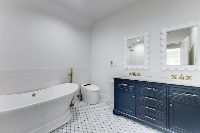 bathroom with vanity, a tub to relax in, and vaulted ceiling