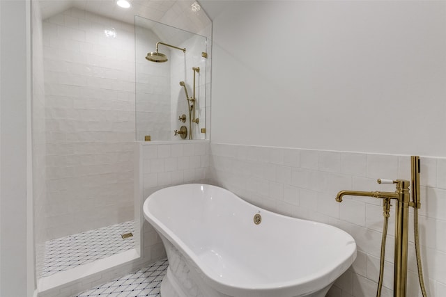 bathroom with lofted ceiling, separate shower and tub, and tile walls