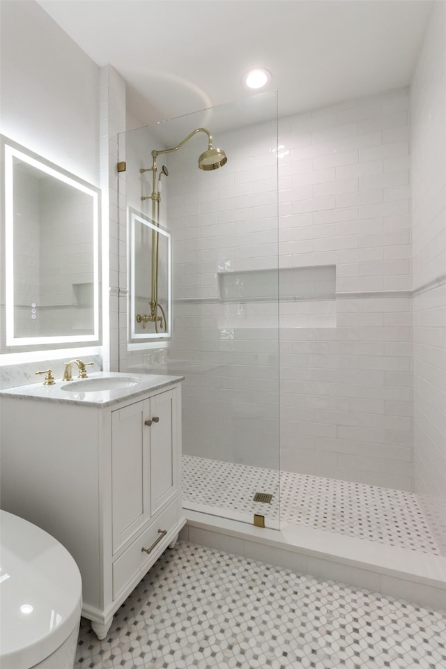 bathroom featuring a tile shower, toilet, tile patterned flooring, and vanity