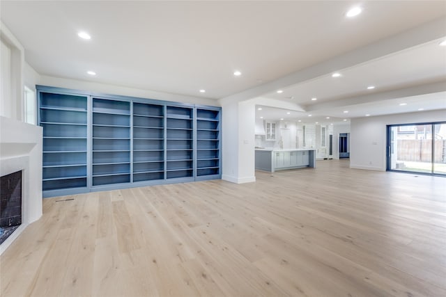 unfurnished living room featuring light hardwood / wood-style floors and sink