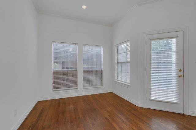 spare room featuring crown molding and dark hardwood / wood-style flooring