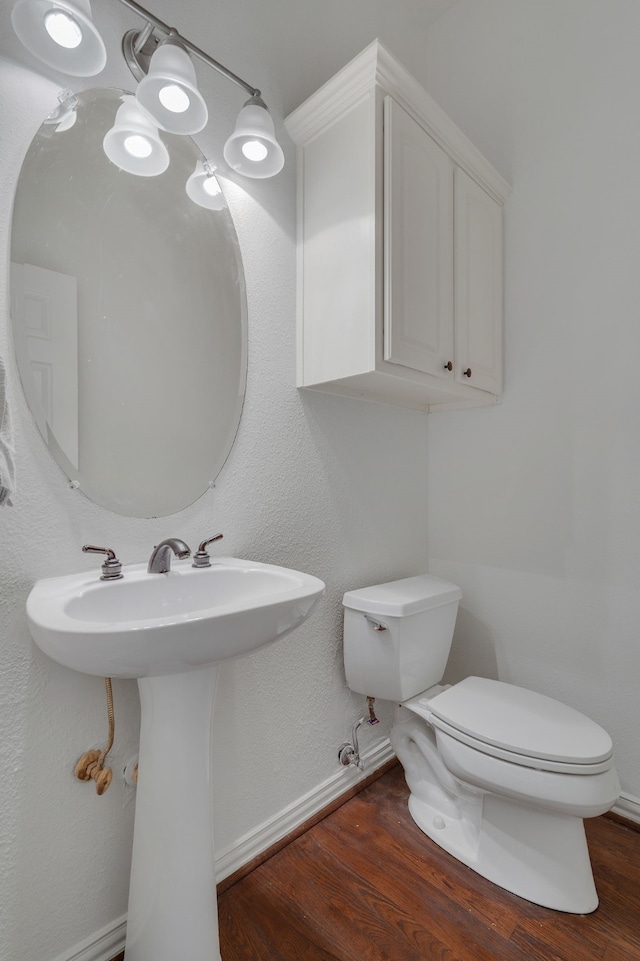 bathroom featuring wood-type flooring and toilet