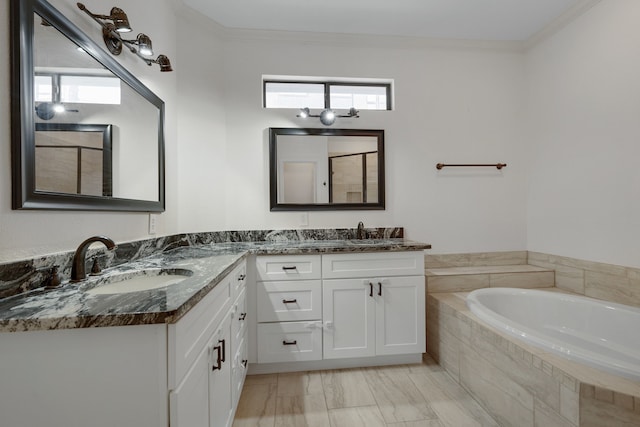 bathroom with a relaxing tiled tub, ornamental molding, and vanity