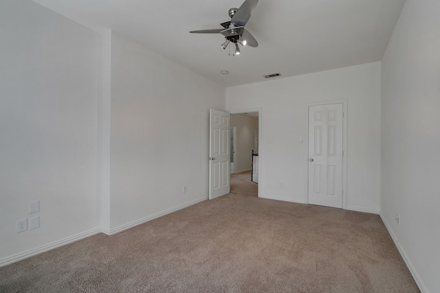 empty room featuring ceiling fan and light colored carpet