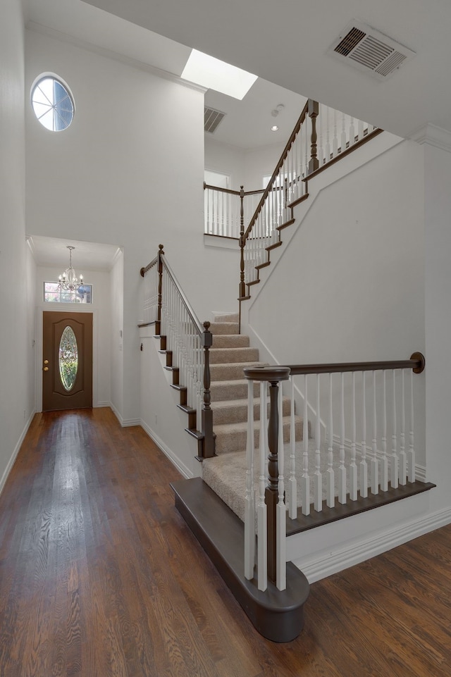 foyer with an inviting chandelier, dark hardwood / wood-style flooring, and plenty of natural light