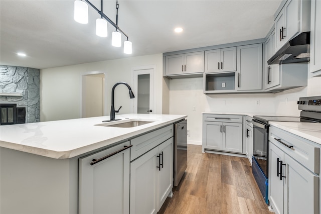 kitchen featuring pendant lighting, sink, gray cabinets, appliances with stainless steel finishes, and hardwood / wood-style floors