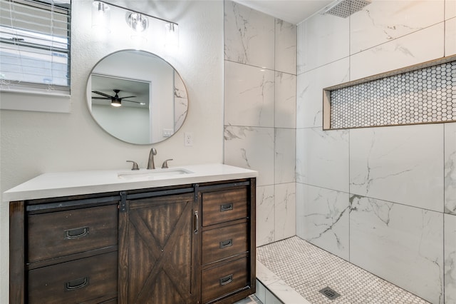 bathroom with a tile shower, ceiling fan, and vanity