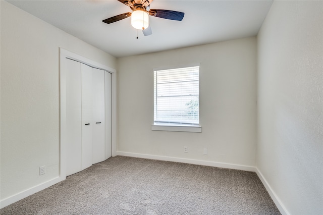 unfurnished bedroom featuring carpet, ceiling fan, and a closet