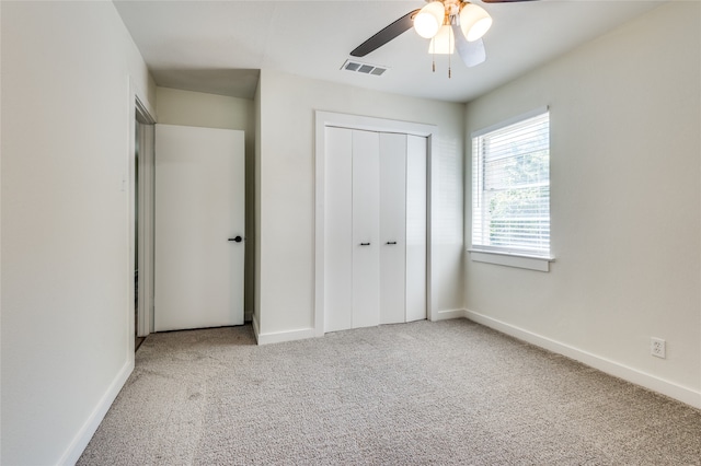 unfurnished bedroom with a closet, carpet, and ceiling fan