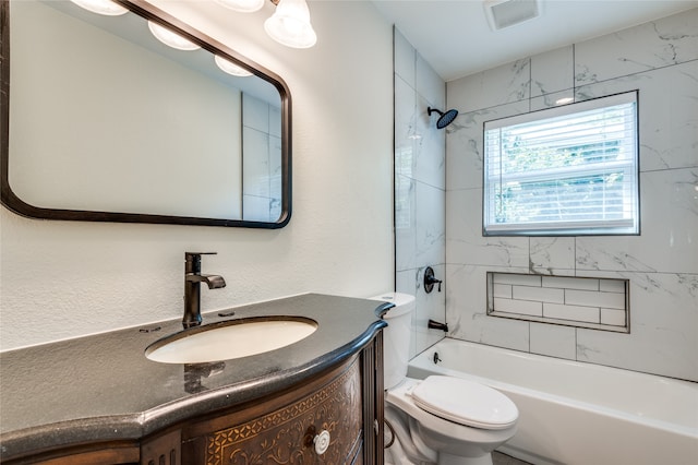 full bathroom featuring vanity, tiled shower / bath combo, and toilet