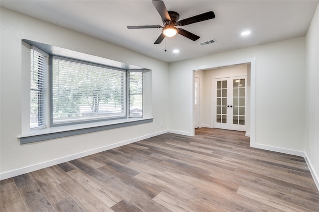 empty room with light wood-type flooring, ceiling fan, and french doors