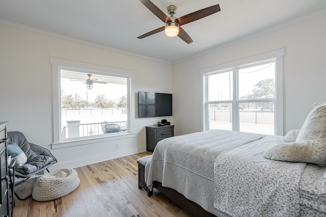 bedroom featuring light wood-type flooring, crown molding, ceiling fan, and multiple windows