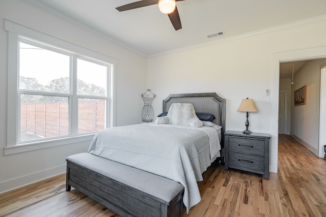 bedroom featuring ceiling fan, light hardwood / wood-style flooring, and ornamental molding