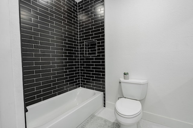 bathroom featuring tiled shower / bath combo, toilet, and tile patterned floors