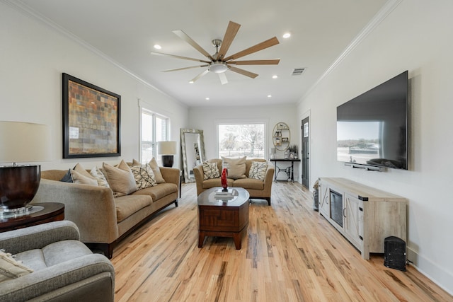 living room featuring light wood-type flooring, crown molding, and ceiling fan