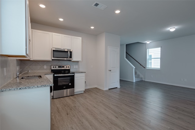 kitchen featuring light hardwood / wood-style flooring, white cabinetry, stainless steel appliances, and sink