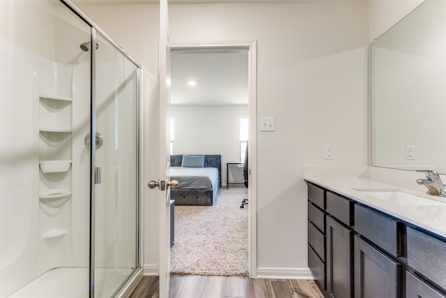 bathroom with vanity, a shower with shower door, and wood-type flooring