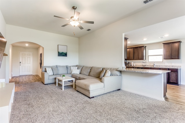 living room featuring light wood-type flooring and ceiling fan