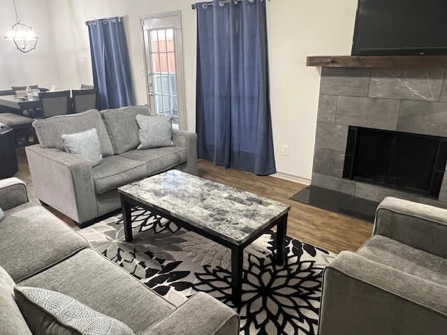 living room with an inviting chandelier and hardwood / wood-style flooring