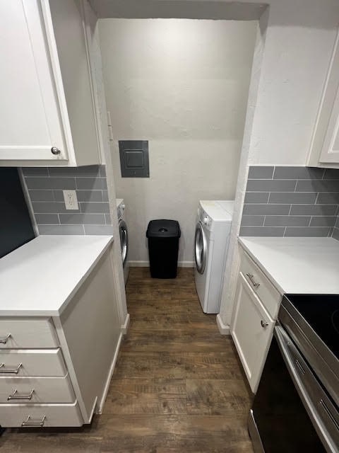 laundry area with washer / clothes dryer, electric panel, and dark hardwood / wood-style floors