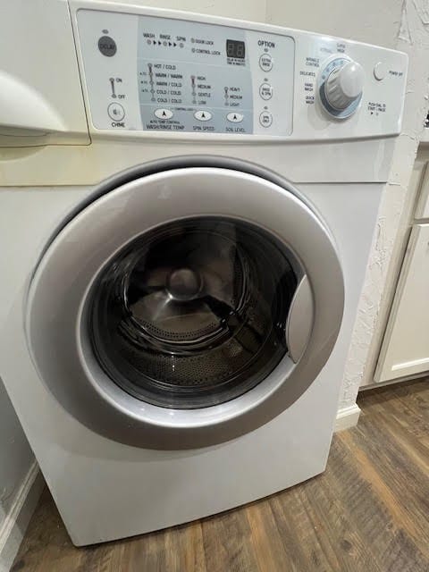 laundry room with washer / clothes dryer and dark wood-type flooring