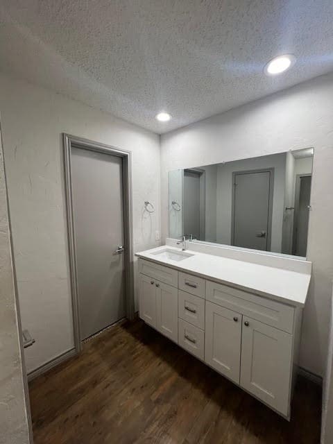 bathroom featuring a textured ceiling, vanity, and hardwood / wood-style floors