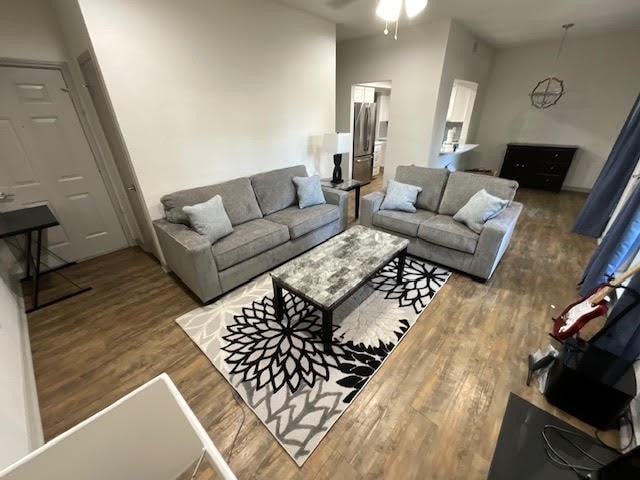 living room with ceiling fan and dark wood-type flooring