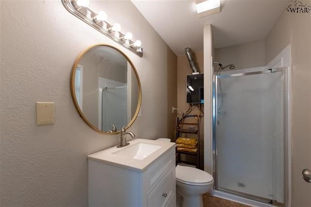 bathroom with vanity, toilet, and a shower with door