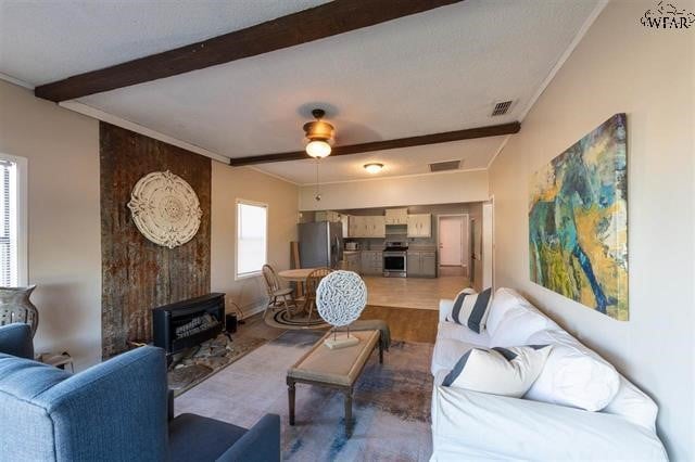 living room with tile patterned flooring, ceiling fan, and beamed ceiling