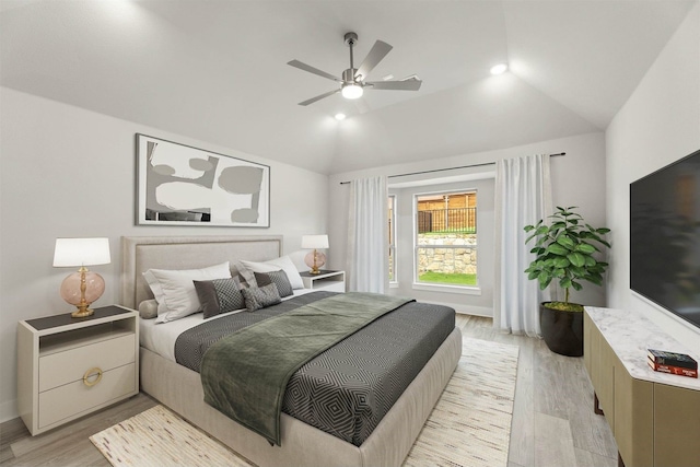 bedroom with ceiling fan, light hardwood / wood-style floors, and lofted ceiling