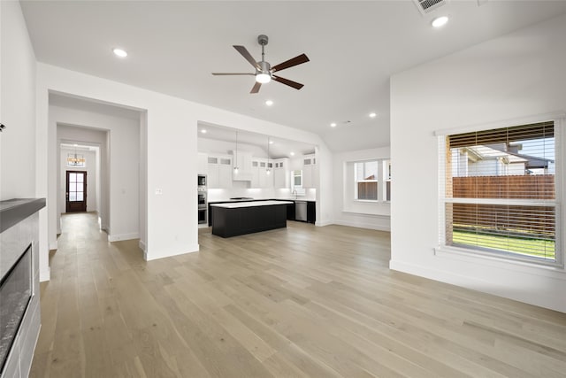 unfurnished living room featuring ceiling fan, light hardwood / wood-style floors, and a wealth of natural light