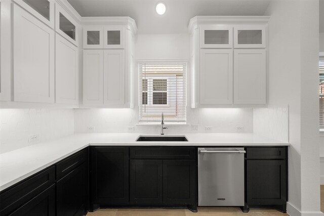 kitchen featuring dishwasher, decorative backsplash, white cabinetry, and sink